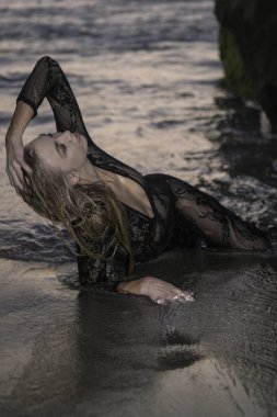 Sahil kayalar üzerinde güzel sarışın kadın