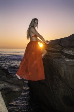 Sahil kayalar üzerinde güzel sarışın kadın