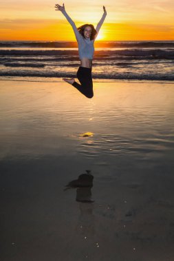 gün batımında plajda atlama kadın
