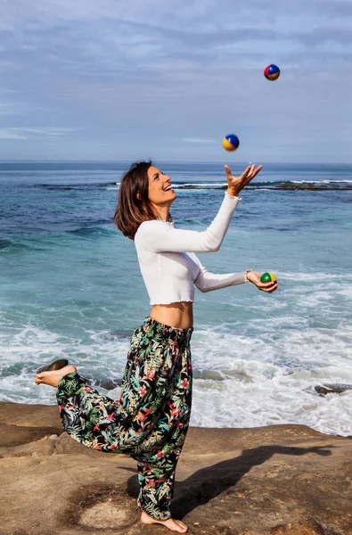 Femme jonglant au bord de l'océan — Photo