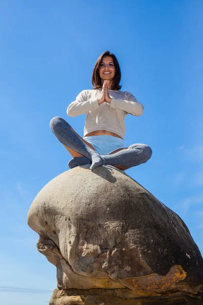 Femme méditant sur un rocher — Photo