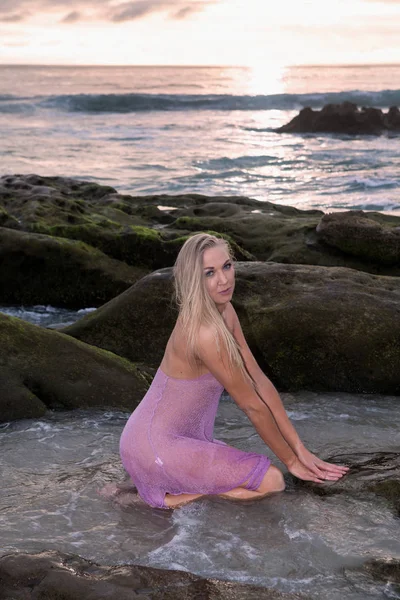 Krásná žena na pobřeží při západu slunce — Stock fotografie