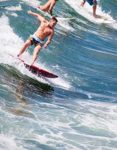 Серфер плывет по волнам на тихоокеанском пляже — стоковое фото
