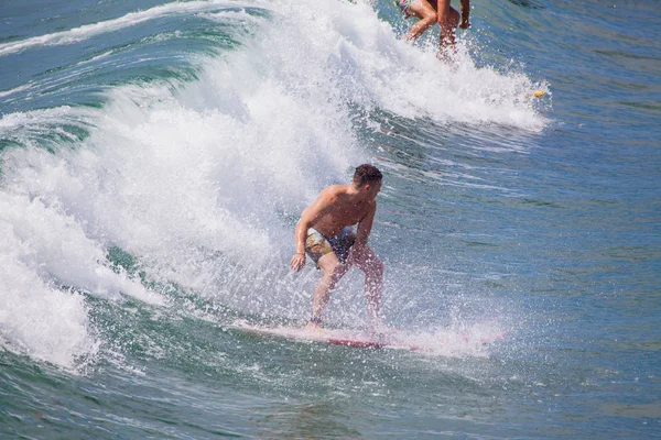 Szörfös iding a hullámok a csendes-óceáni strandon — Stock Fotó