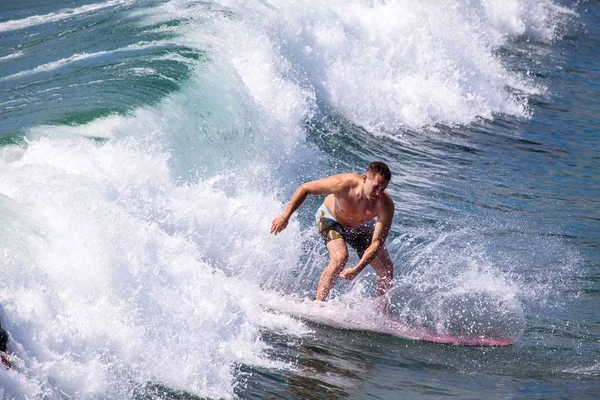 Surfista montando las olas en la playa pacífica — Foto de Stock