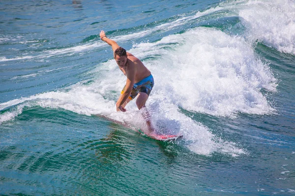 Серфер катается на волнах на тихоокеанском пляже — стоковое фото