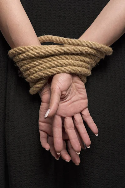 Womans hands on back tied with a rope, long nails