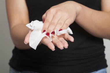 Genç kadın ıslak mendille ellerini temizliyor.