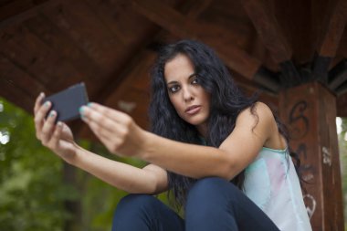 Sosyal ağ - yarış genç kadın kullanım akıllı telefon gülümseyen karışık. O arkadaşları temas olması için telefon kullanır