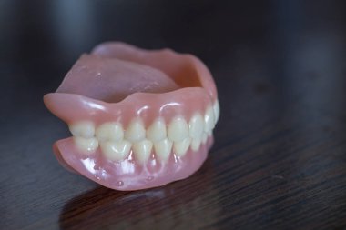 The artificial medical denture on black background clipart
