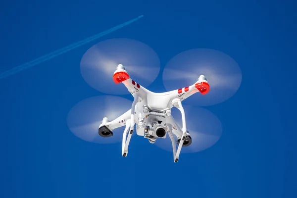 Квадрокоптер с камерой в небе вместе с самолетом — стоковое фото