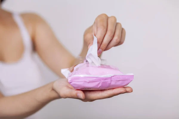 Woman open package of wet wipes and use it for cleaning