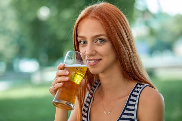 맥주를 마시는 아름다운 귀여운 빨간 머리 여자 — 스톡 사진