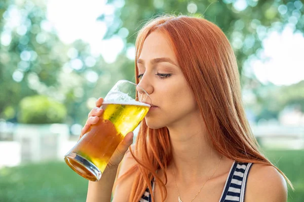 かわいい赤毛の女性はビールを飲む — ストック写真