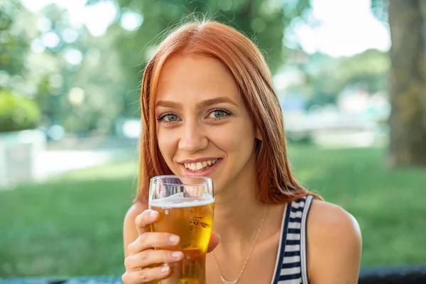 美しい笑顔かわいい赤毛の女性はビールを飲んで — ストック写真