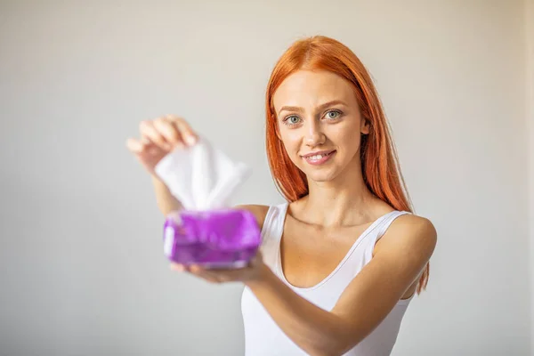 Wet wipes: women take one wipe from package for cleaning