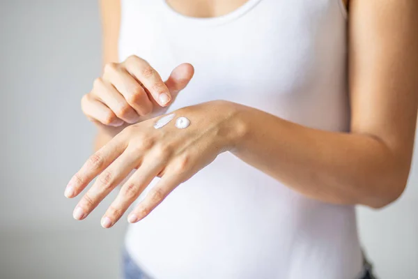 Mujer aplicando crema de manos - foto de stock — Foto de Stock