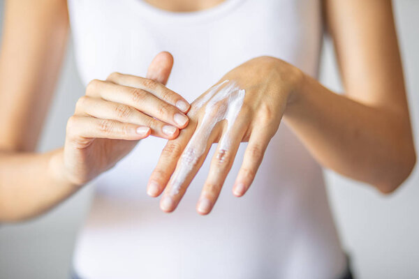 Woman applying hand cream - stock photo