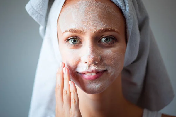 Женщина моет лицо и кожу мылом и увлажнением — стоковое фото