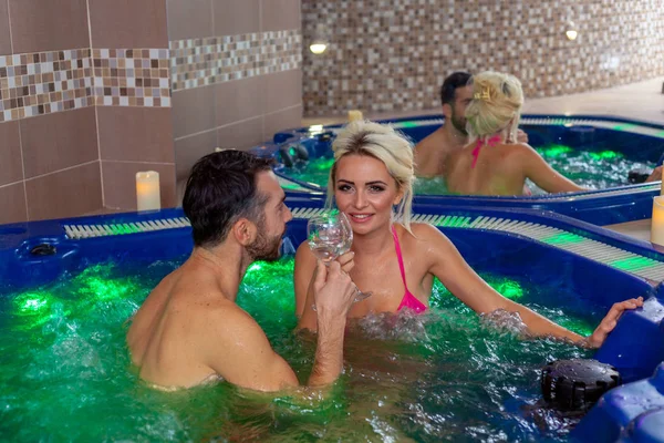 Wine and jacuzzi - couple relaxing in spa center stock photo — Stock Photo, Image
