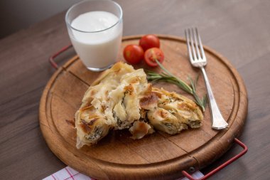 Peynirli ve ıspanaklı Burek ya da bourek turtası vooden masada servis edilir.