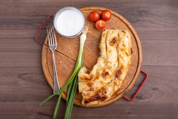 Borek ya da Burek turtası ve ahşap masada beyaz peynir.