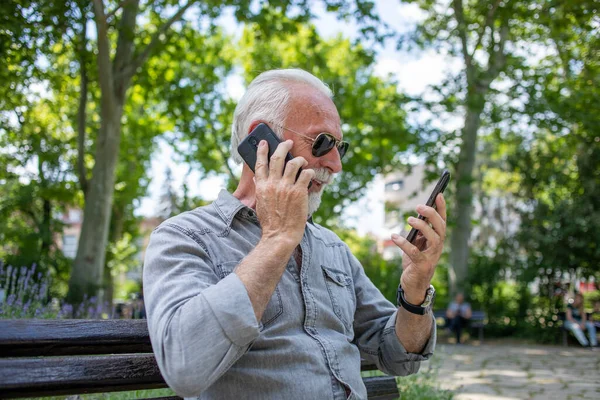 Starý Muž Porovnat Dva Smartphony — Stock fotografie