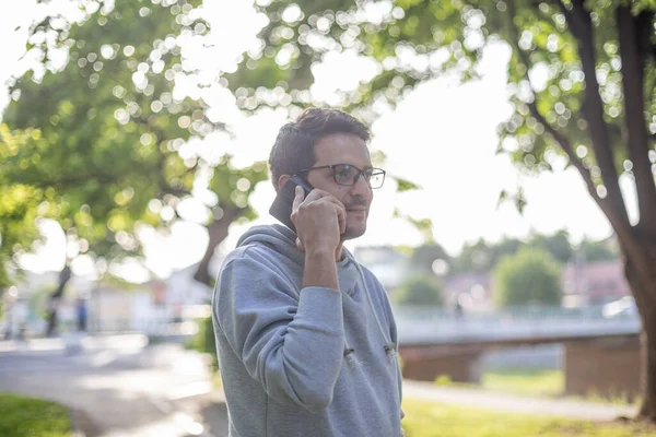 Parkta Açık Havada Arka Planda Akıllı Telefondan Konuşan Bir Adam — Stok fotoğraf