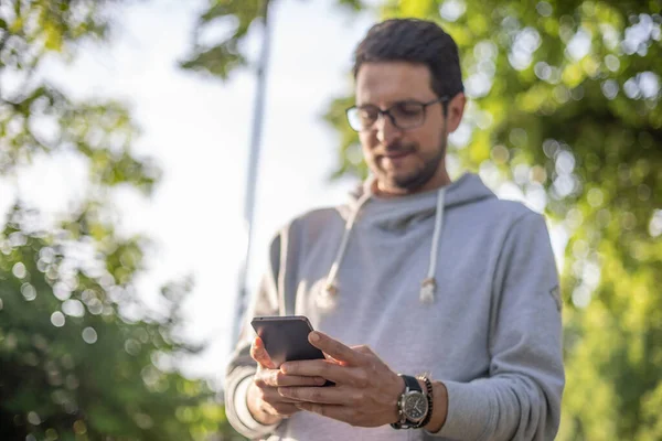 Smart Ser Man Sms Meddelande Smartphone Utomhus Park Skjuta Bakgrundsbelysning — Stockfoto