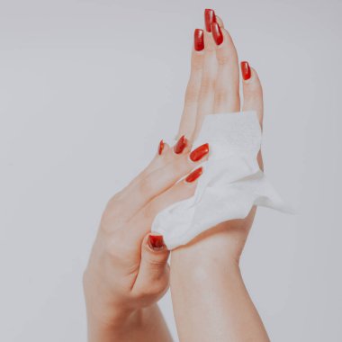 Genç kadın ıslak mendille ellerini temizliyor.