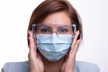 Yüz maskesi ve koruyucu gözlük takan doktor ya da hemşire portresi.