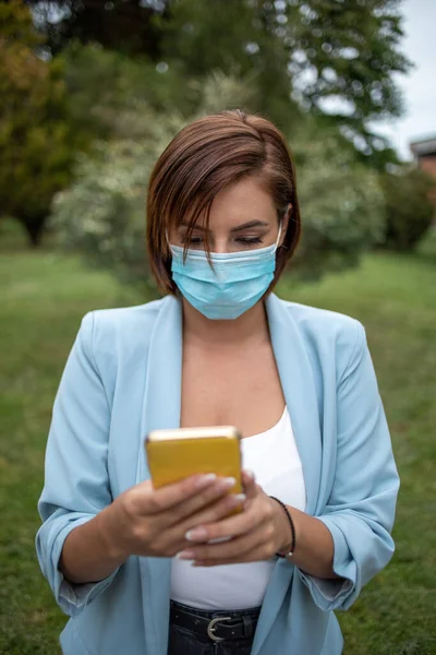 Donna Con Maschera Blu Utilizzando Telefono Foto Scorta All Aperto — Foto Stock