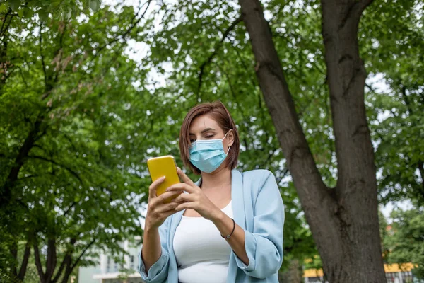 Donna Con Maschera Blu Utilizzando Telefono Foto Scorta All Aperto — Foto Stock