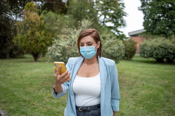 Donna Con Maschera Blu Utilizzando Telefono Foto Scorta All Aperto — Foto Stock