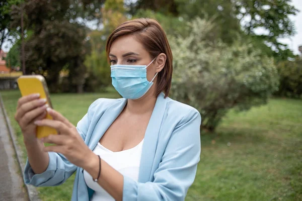 Donna Con Maschera Blu Utilizzando Telefono Foto Scorta All Aperto — Foto Stock