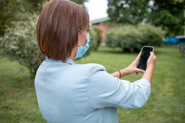 Donna Con Maschera Blu Utilizzando Telefono Foto Scorta All Aperto — Foto Stock