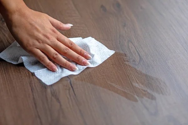 Woman\'s hand cleaning office table surface with wet wipes