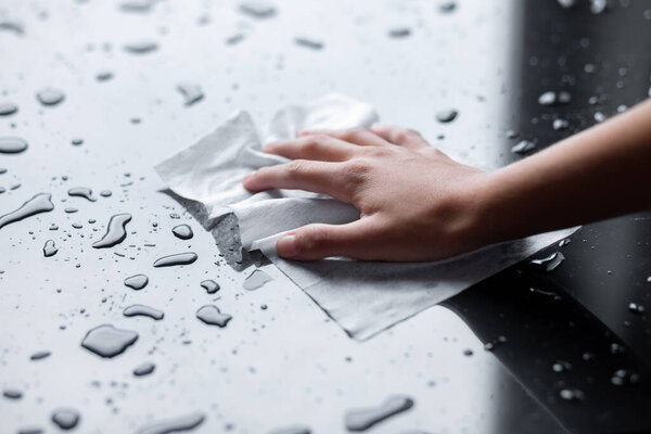 Woman hand clean cleaning liquid water drops with wipe or tissues