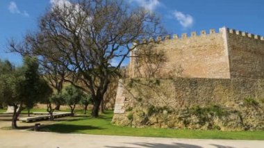 Lagos, Portekiz - Mayıs 2018 yaklaşık: Görünüm giriş Arch ön plan ve ayarı, Lagos, Algarve, Portekiz zevk turistlerin palmiye ağaçları ile valilerin kale (Castelo dos Governadores),