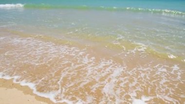 Kumlu sahilde çökmesini yumuşak mavi okyanus dalgaları.