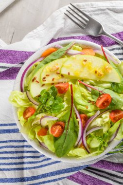 Elma dilim masa üzerinde beyaz seramik kase lezzetli sebze salatası.