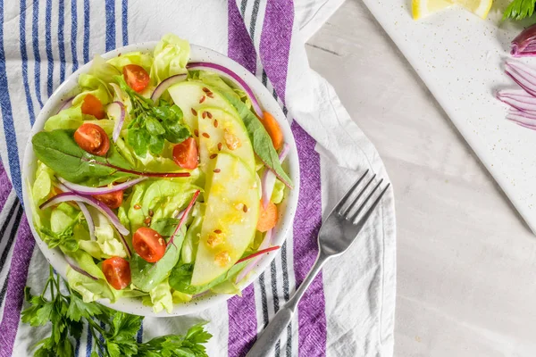 Elma dilim masa üzerinde beyaz seramik kase lezzetli sebze salatası.