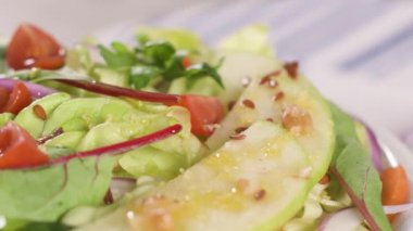 Elma dilim masa üzerinde seramik kase lezzetli sebze salatası.