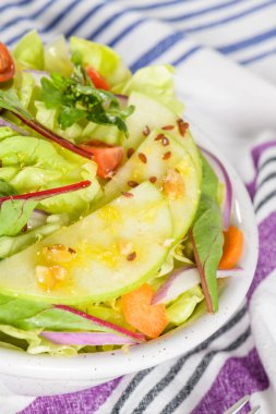 Elma dilim masa üzerinde beyaz seramik kase lezzetli sebze salatası.