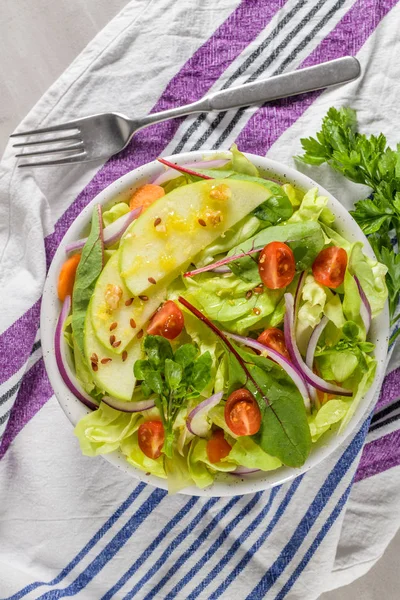 Elma dilim masa üzerinde beyaz seramik kase lezzetli sebze salatası.