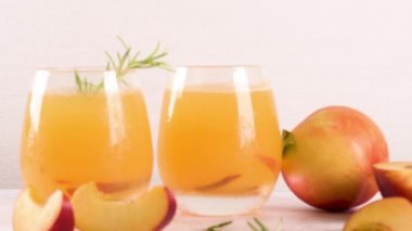 Ev yapımı şeftali suyu buz küpleri ve biberiye ile cam mermer taş zemin üzerine bırakır..