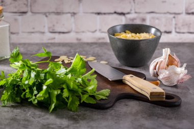 Mutfak Tezgah üzerinde taze bahçe otlar. Maydanoz, sarımsak, bıçak ve almons. Gıda, kavramını sağlıklı gıda.