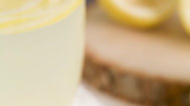 Soğuk limonata veya alkollü kokteyl limon, biberiye ve hafif bir arka plan üzerinde cam bardaklarda buz ile.