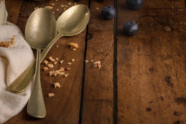 Yaban mersini ve granola yoğurt parfe. Sağlıklı kahvaltı kavramı mason kavanoza ahşap masa üzerinde dekoratif kaşık ile devam eder.