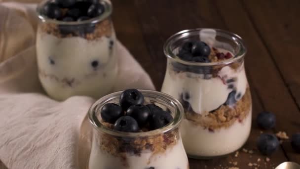 Áfonya Granola Joghurt Parfé Egészséges Reggeli Koncepció Befőttesüvegbe Tálalva Fából — Stock videók